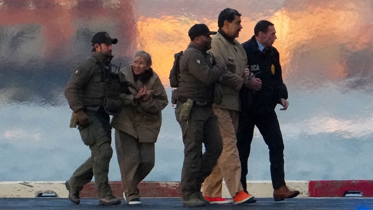 Cilia Flores camina con Nicolás Maduro, sujetados por agentes de la DEA. Foto: Reuters.