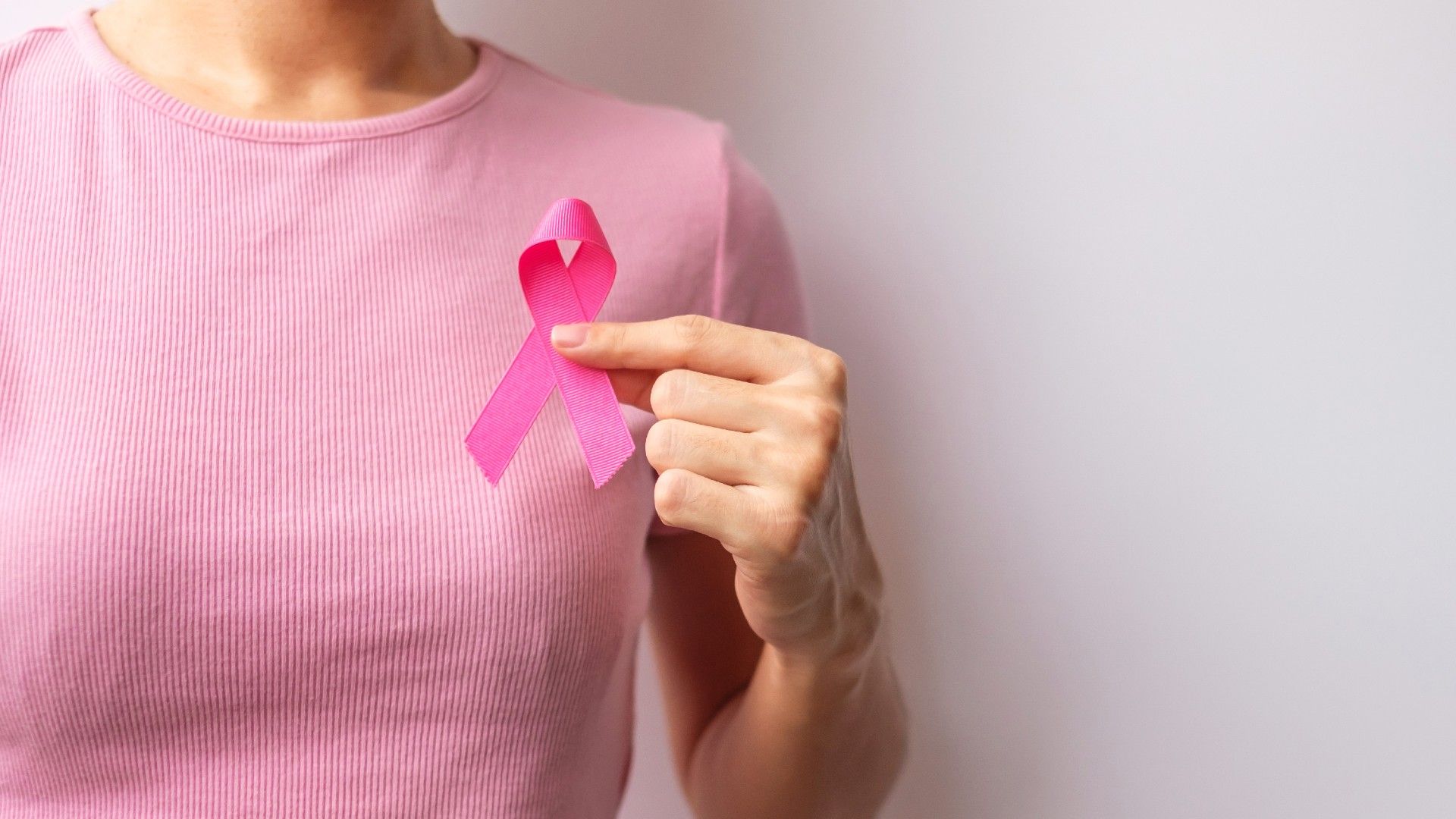 pink-october-breast-cancer-awareness-month-woman-hand-hold-pink-ribbon-and-wear-shirt-for-support-people-life-and-illness-national-cancer-survivors-month-mother-and-world-cancer-day-concept.jpg